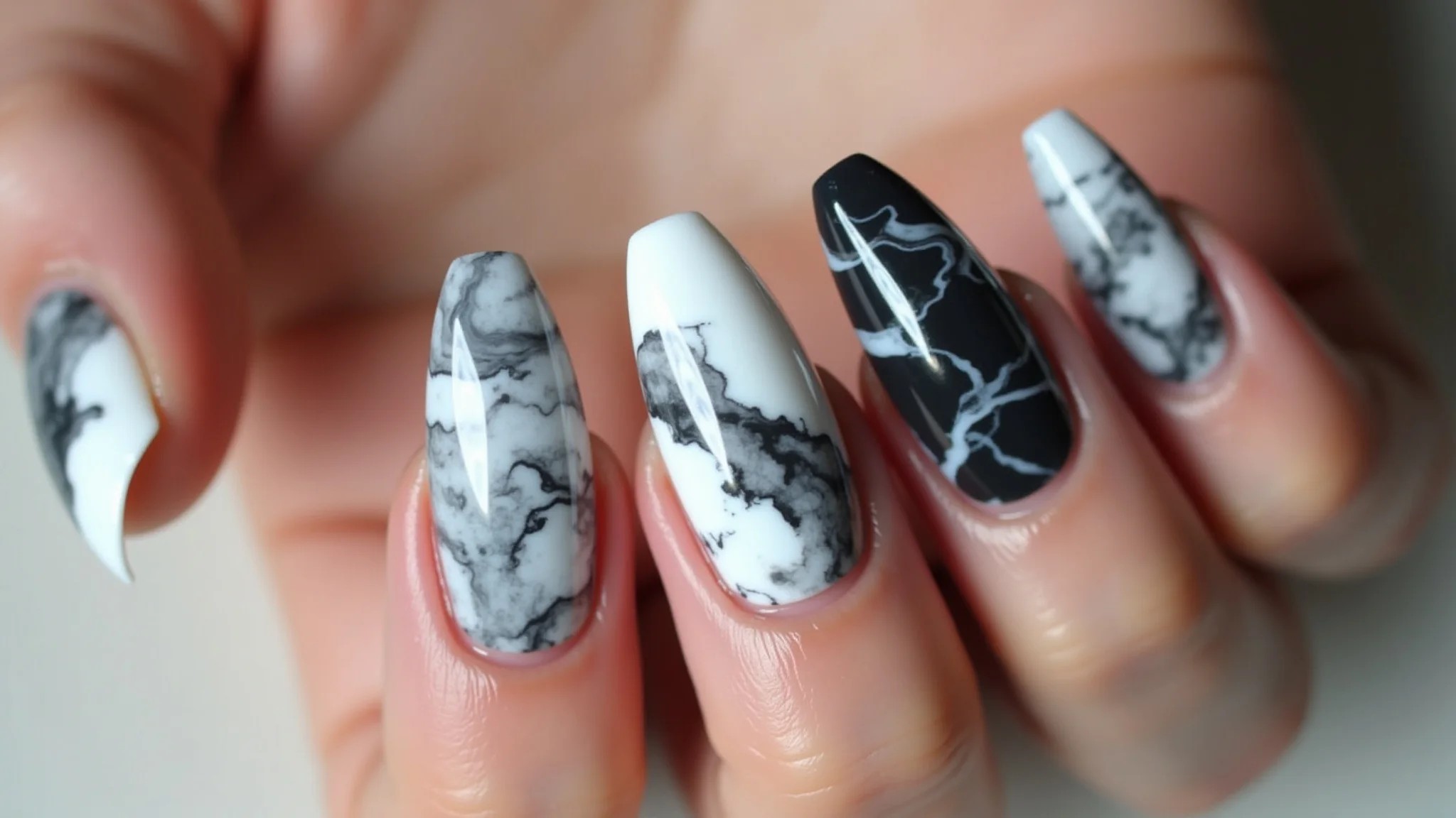 Unhas de fibra com efeito mármore sofisticado em tons de branco, cinza e preto.
