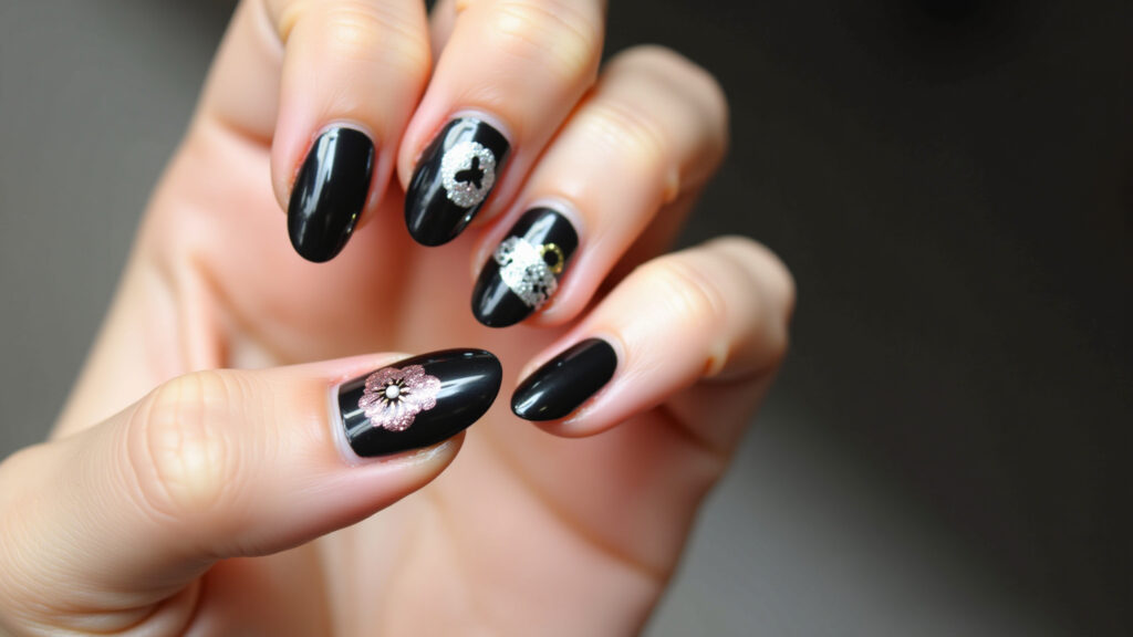 Unha preta com glitter e adesivos.