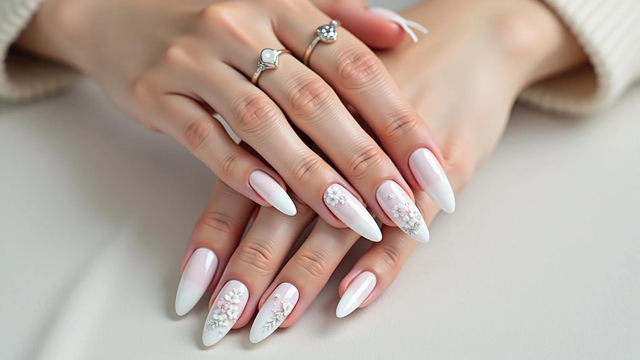 Unhas brancas com delicadas flores brancas, estilo romântico e charmoso.