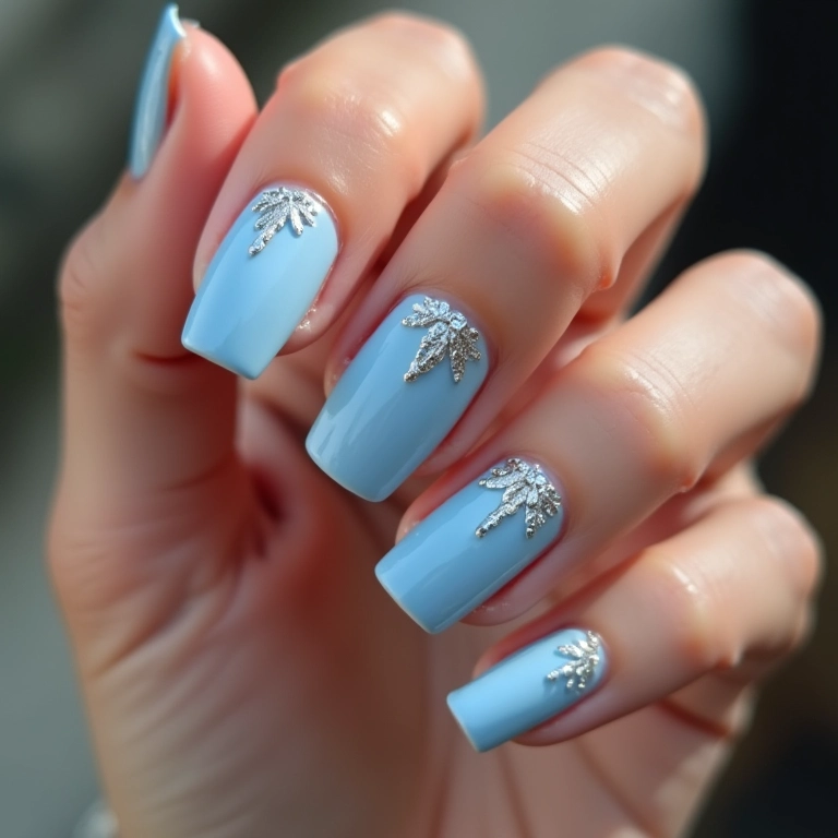 Unhas azul bebê com detalhes em glitter prata.