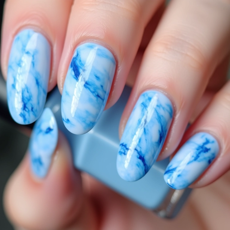Unhas de gel azul claro com efeito marmorizado.