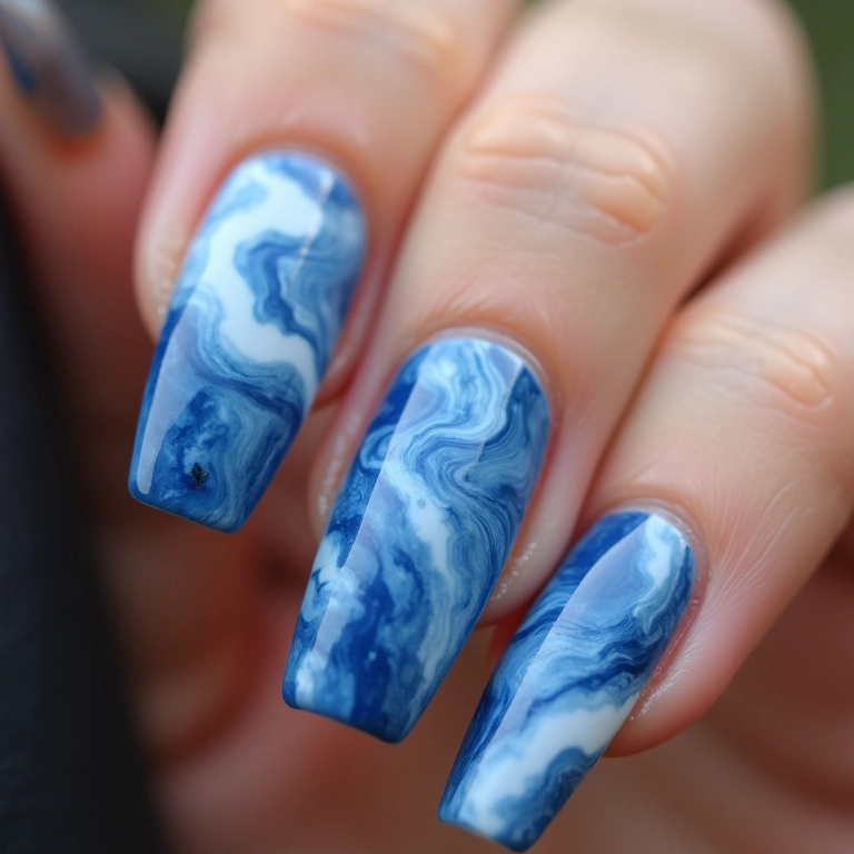 Unhas marmorizadas em tons de azul e branco para festa.