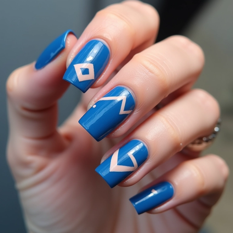 Unhas quadradas azuis com desenhos geométricos.
