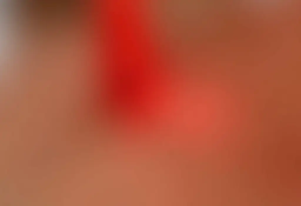 Aplicação de esmalte vermelho em unhas bem cuidadas