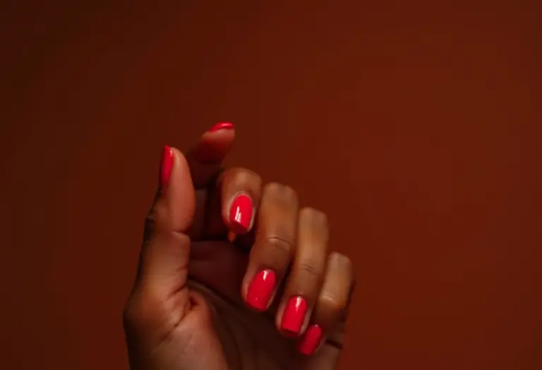 Mãos femininas com unhas impecáveis e esmalte vibrante