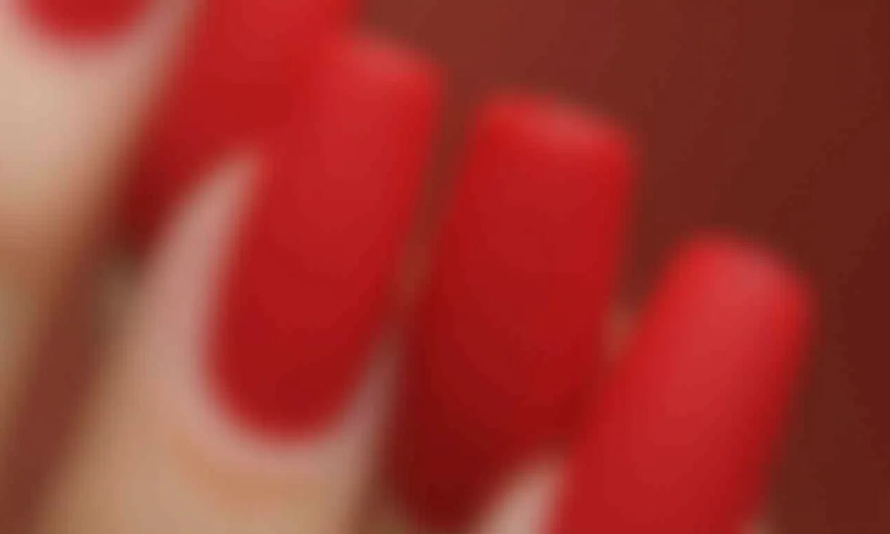 Unha vermelha fosca com detalhes brilhantes.