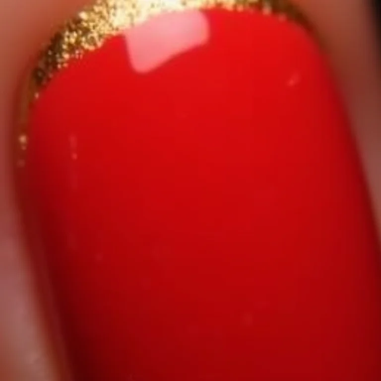 Francesinha dourada em unhas vermelhas
