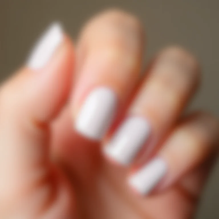 Mão com unhas brancas impecáveis.