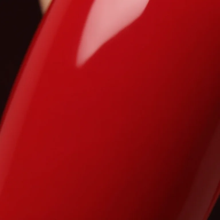 Mãos femininas com unhas vermelhas e brilhantes pintadas com esmalte Risqué Diamond Gel.