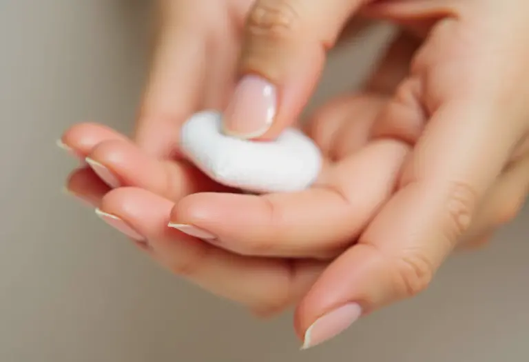 Mãos segurando algodão com removedor de esmalte caseiro