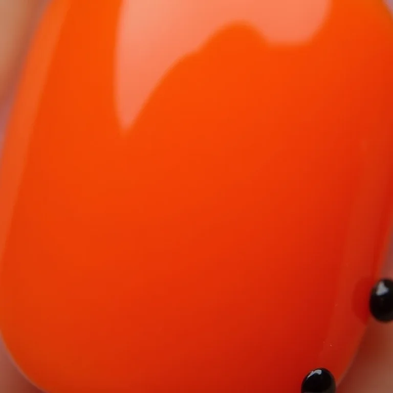 Unhas laranja com pedrarias pretas
